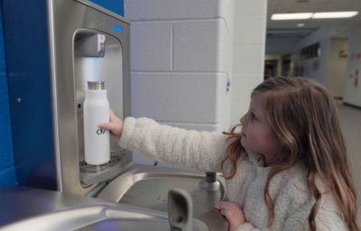 girl filling bottle at school water station