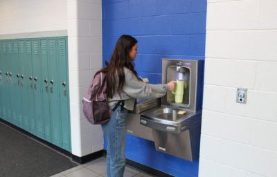 girl filling bottle at school water station