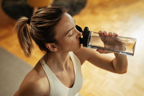 person drinking water in gym